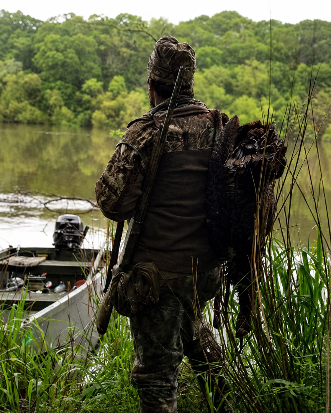 A turkey hunter returning to the boat at the water’s edge